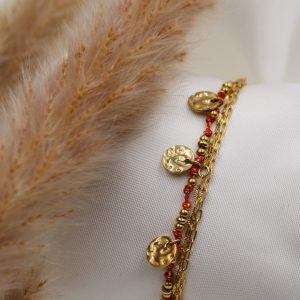 médaillon doré et fil rouge