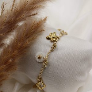 bracelet beige et doré à breloque